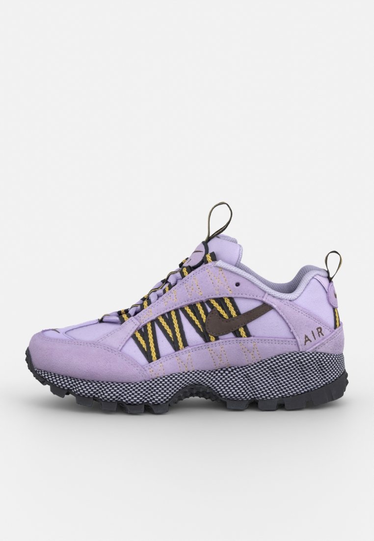 Baskets de sport violettes avec des accents de rayures noires et jaunes, tige texturée, semelle en caoutchouc épaisse et détail "AIR" sur le talon.