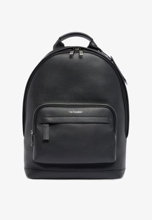 Mochila de cuero negro con forma redondeada, acabado texturizado, asa superior y un bolsillo frontal con cremallera. Presenta herrajes en tono plateado.