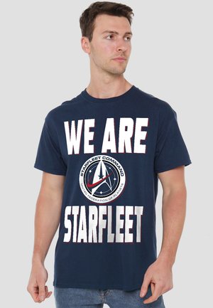 Navy blue cotton t-shirt featuring large white text "WE ARE STARFLEET" and a circular emblem with "STARFLEET COMMAND" in the center.