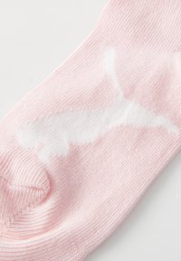 Calcetín de algodón color rosa pálido con un diseño de logo blanco, textura suave y puño acanalado para un ajuste ceñido.