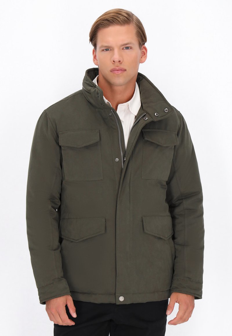 Olivgrüne isolierte Jacke mit hohem Kragen, Reißverschluss und vier Fronttaschen. Glatte Textur und minimale Hardware-Details.