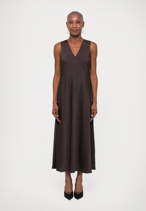Donkerbruin, mouwloos jurkje met een V-hals en een A-lijn silhouette, met een gladde textuur en een midi-lengte. Zwarte hakken maken de look compleet.