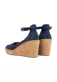 Tamnoplave suede platform sandale s otvorenim prstima i trakama oko gležnja; potplati omotani jutom s teksturiranim završetkom.