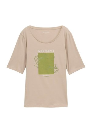 Tricou bej cu mâneci scurte, fabricat dintr-un material moale, având un design floral verde suprapus și cuvântul "BLOOMING" scris cu text alb.