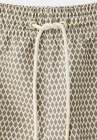 Short beige et blanc à motif losanges avec taille élastique et cordon blanc noué en nœud à l'avant au centre.