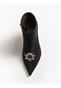 Stivaletto in pizzo nero con punta affusolata, caratterizzato da un embellishment decorativo in oro e strass sulla parte anteriore e una cerniera laterale.