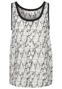 Hedvábná bezrukávová košile s černo-bílým geometrickým trojúhelníkovým vzorem, s černým lemováním kolem výstřihu a armhole. Měkká tkanina.