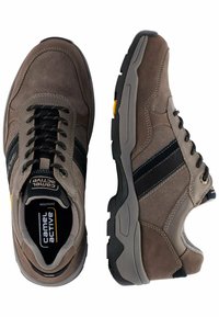 Braune Wildledersneaker mit schwarzen Streifenakzenten, ausgestattet mit einer robusten Gummisohle, runder Zehenpartie und strukturierten Details im Obermaterial.
