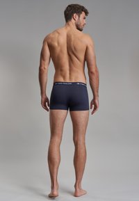 Boxer-briefs navy pour homme en tissu doux avec une ceinture bleu contrastée arborant le logo "Tom Tailor" à l'avant.