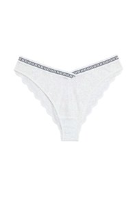 Biała koronkowa stringi z kwiatowym wzorem, falbankowymi brzegami oraz paskiem w czarno-białe paski z powtarzającym się logo marki.