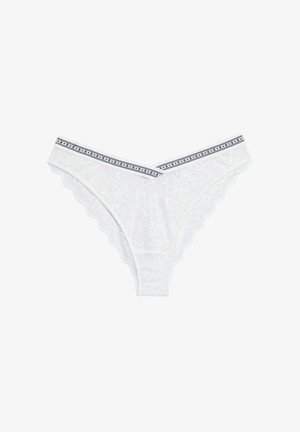 White lace thong with floral pattern, scalloped edges, and a black-and-white striped waistband featuring repeated brand logo.