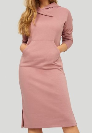 Lichtroze hoodie-jurk met een zak aan de voorkant, lange mouwen en een hoekige halslijn. Voorzien van zijsplitten en gemaakt van een zachte katoenmix.
