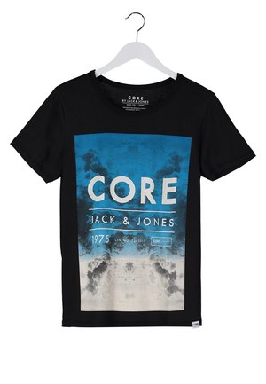 Czarna koszulka z niebieskim nadrukiem, jasnoniebieskie dżinsy i trampki z niebieskimi akcentami. Widoczne brązowe paski od plecaka. Codzienny strój.