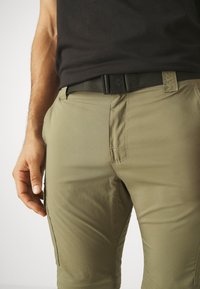 Khaki cargo bukser med en glat tekstur, prydet med sidelommer og broderede detaljer. Sammen med et sort, vævet bælte.