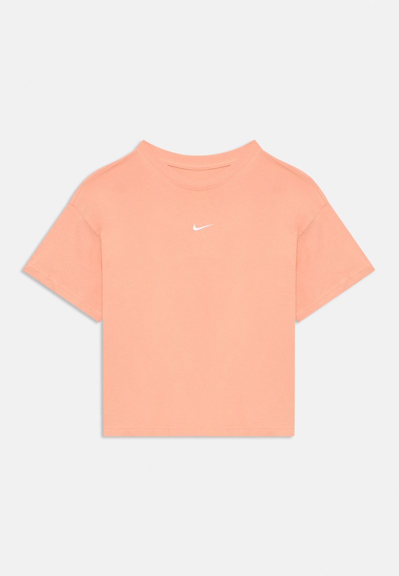 Kratki rukavi, krojeni majica u svijetlo breskvastoj pamuku s okruglim izrezom i kontrastnim bijelim Nike logom na prsima. Glatka tekstura.