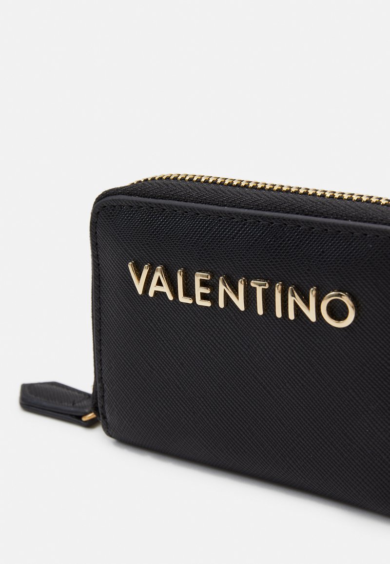 Monedero negro con cremallera en material texturizado y logo "VALENTINO" en tono dorado, con una forma rectangular elegante y un hardware de cremallera suave.