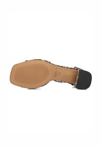 Sandale à imprimé animal noir et beige avec une tige lisse, un talon bloc, une semelle en caoutchouc et un fond texturé pour une meilleure adhérence. Taille 38.