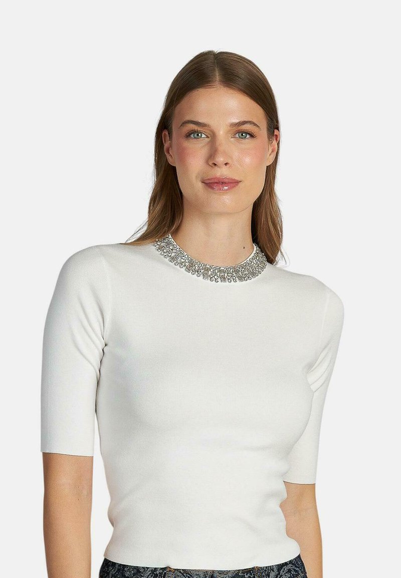 Weißes T-Shirt mit kurzen Ärmeln, taillierter Passform und verziertem silbernen Kragen. Glatte Textur und klare Silhouette.