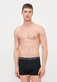Schwarze Boxershorts aus weichem Stoff mit einem einfarbigen Design und einem Logo-Bund. Die Passform ist enganliegend und der Stil ist modern.