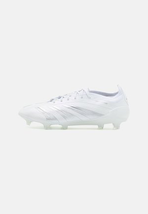 Botín de fútbol blanco con una parte superior lisa y texturizada, acentos plateados y tacos transparentes; diseñado para un rendimiento óptimo en superficies de hierba.