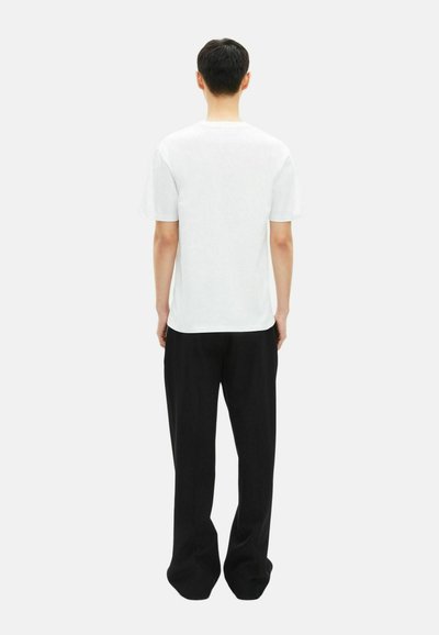 White short-sleeve t-shirt and black wide-leg pants viewed from the back, featuring a simple design and relaxed fit.