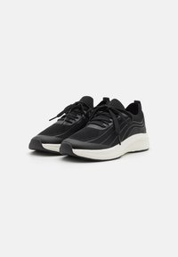 Black athletic shoes with a mesh upper, textured pattern, and white midsole. Features round laces and a cushioned design.