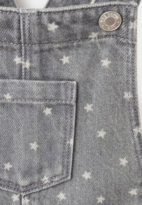 Sive farmerke s uzorkom zvijezda, s prednjim džepom, pojačanom šavovima i detaljima u metalnom gumbu.