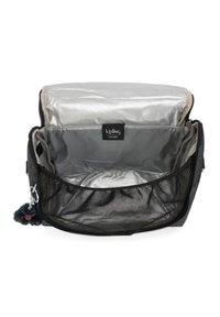 Černá taška Kipling uvnitř, se stříbrnou podšívkou a síťovanou kapsou. Obsahuje malou modrou pom-pom kouli připevněnou pro dodatečný detail.