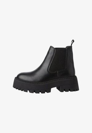 Black leather ankle boot with a chunky rubber sole, elastic side panels, and a pull tab. Features a smooth texture with contrast stitching.
