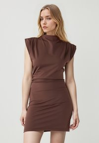 Braun gefüttertes Kleid mit einem hohen Kragen, kurzen Puffärmeln und einem gerafften Bund. Glattes, dehnbares Material mit einer eleganten Silhouette.