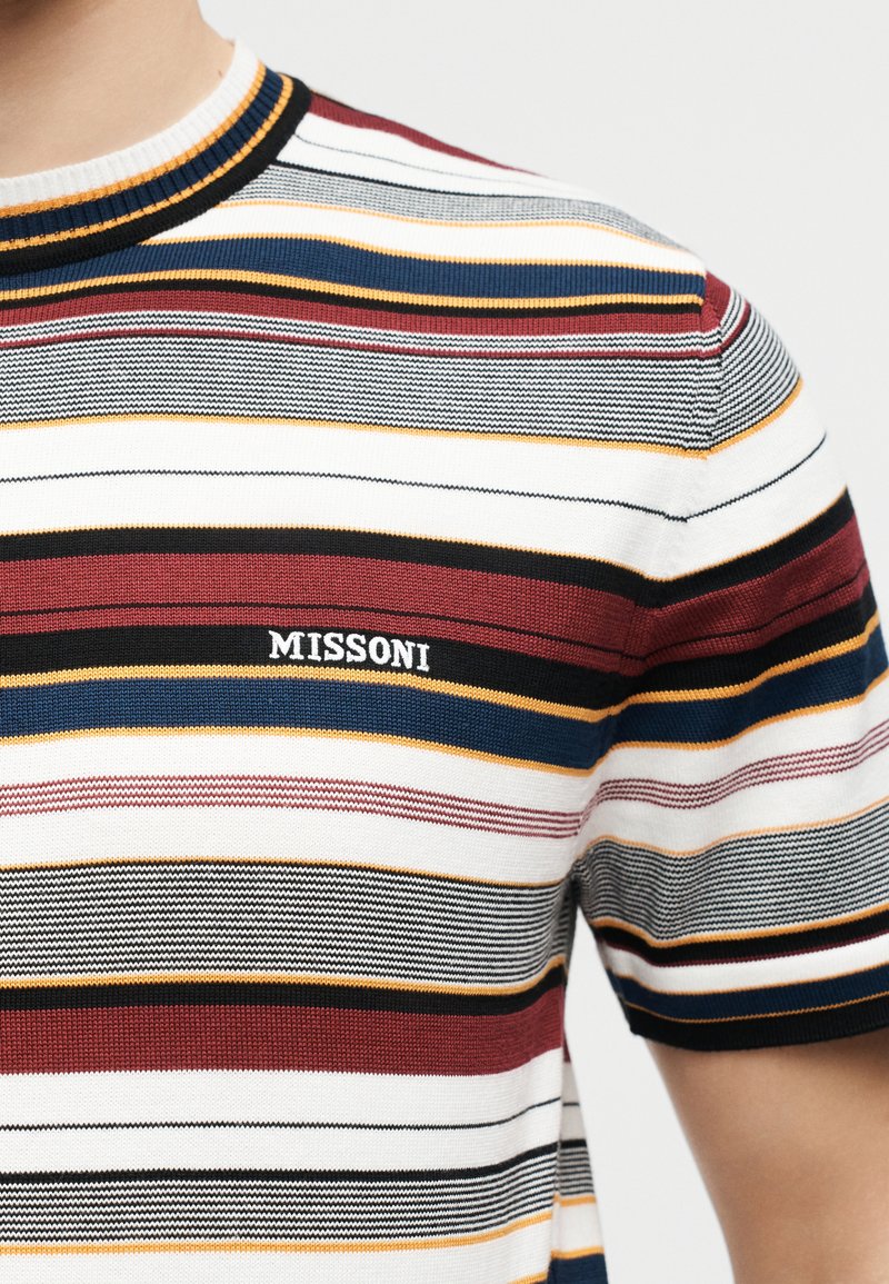 Close-up of a short-sleeve knit shirt with horizontal stripes in burgundy, navy, black, mustard, white, and gray, featuring "MISSONI" logo on chest.