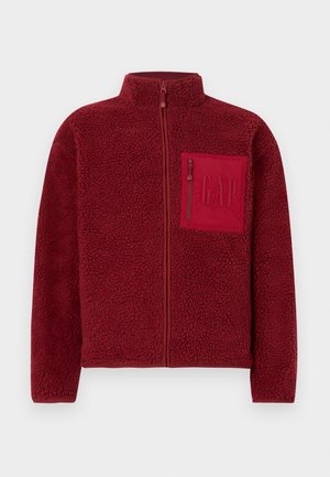 Rød fleecejakke med hel glidelås, høy krage og glidelåslomme på brystet med preget GAP-logo.