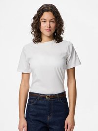 Λευκό βαμβακερό μπλουζάκι με κοντά μανίκια, λαιμόκοψη στρογγυλή και άνετη εφαρμογή, σε συνδυασμό με σκούρα μπλε τζιν και καφέ δερμάτινη ζώνη.