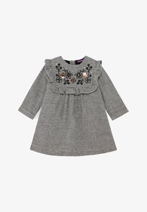 Langemouwen zwart-wit geruite jurk met ruches en bloemrijke borduursels op de borst.