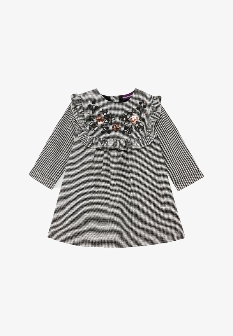 Robe à manches longues à carreaux noir et blanc avec bordure à volants et broderie florale sur la poitrine.