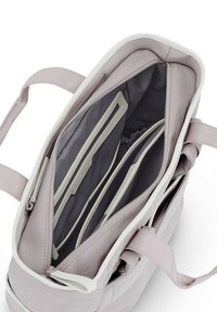 Bolsa vertical de tela púrpura claro con bordes blancos. El interior cuenta con múltiples compartimentos con forro gris y un bolsillo con cremallera.