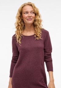 Maglione borgogna a maglia con scollo rotondo, maniche lunghe e polsini a coste, caratterizzato da una texture morbida e una vestibilità comoda.