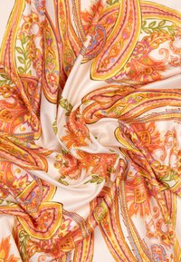 Tissu soyeux présentant un motif floral et cachemire en orange, rose et vert sur un fond crème doux, avec des détails complexes et une texture fluide.