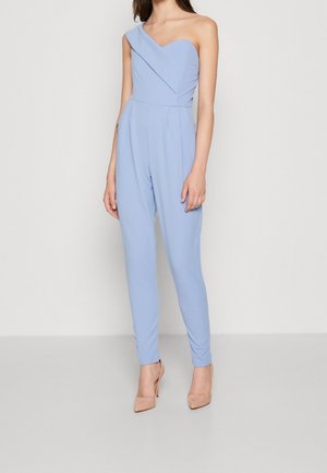 Eén-schouder jumpsuit in lichtblauw, gemaakt van gladde stof. Heeft een getailleerd lijfje en taps toelopende pijpen. Geen zichtbare patronen of hardware.
