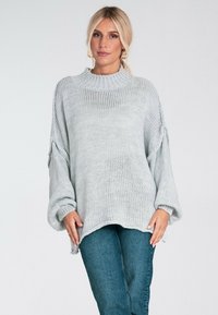 Jasnoszary sweter dziany z wysokim kołnierzem, oversize'owy krój i opadające ramiona. Posiada teksturowaną tkaninę i prążkowane mankiety. Codzienny design.