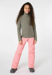 Sudadera de forro polar en verde oliva con cuello de media cremallera y mangas largas, combinada con pantalones rosas y botas grises.