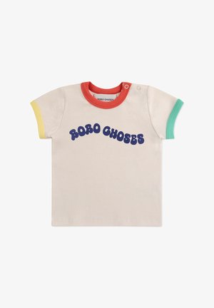 T-shirt a maniche corte, di colore crema e a coste, con polsini multicolori e colletto rosso. Presenta la scritta "ROBO CHOSES" in grassetto, di colore blu, sulla parte anteriore.