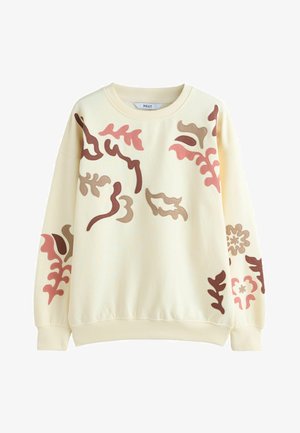 Krēmkrāsas sporta džemperis ar ziedu rakstiem rozā, brūnā un bordo krāsā. Tam ir apaļa kakla izgriezums un ribota aproces un apakšmala. Mīksta tekstūra.