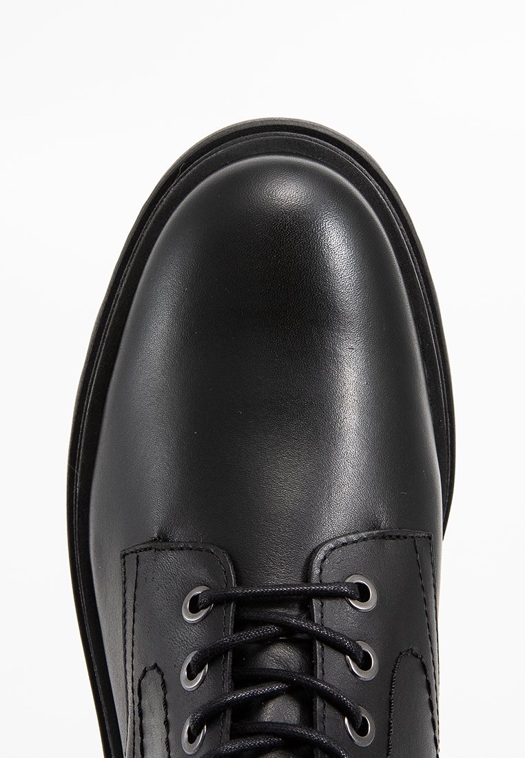 Schwarze Lederhalbschuh mit runder Spitze, Schnürdesign und Metallösen, mit glatter Textur und minimalistischem Stil.