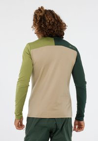 Langemouwen shirt met een kleurblokontwerp in groene en beige secties, gemaakt van een soepele, lichte stof. Textuur van de achterste naden is zichtbaar.