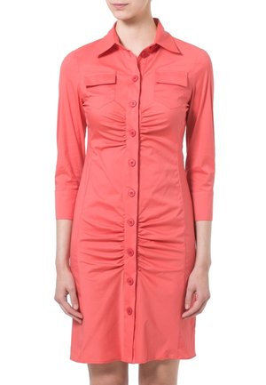 Koralfarvet skjortekjole med trekvartærmer, to brystlommer, rynket front og slank pasform. Glat, letvægtsstof.
