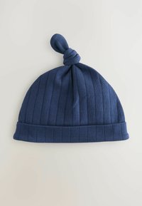 Bonnet en tricot côtelé bleu marine avec un sommet noué, offrant une texture douce et un revers replié pour plus de chaleur et de style.