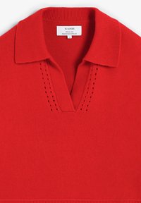 Suéter rojo de punto con cuello acanalado y escote en V, que presenta pequeños detalles perforados a cada lado.