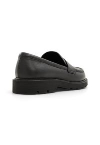 Svarta läderloafers med rund tå, låg klack och texturerad gummisula. Har sömnaddetaljer längs sidorna.