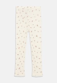 Leggings en tissu crème doux avec un imprimé floral délicat en marron clair, présentant une bordure en dentelle à l'ourlet et une coupe ajustée.